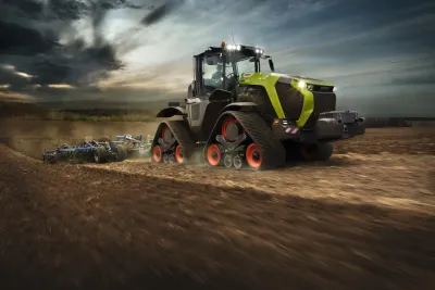 Zelený traktor Claas Xerion 12 na polopásovém podvozku při práci