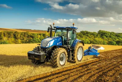 Modrý traktor New Holland T7.340 při orbě pole