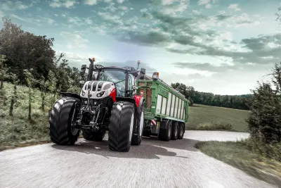 Traktor Steyr Terrus s přívěsem jede po silnici