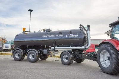 Černá přepravní cisterna Fliegl ROAD X LINE za traktorem