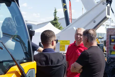 Odborná diskuze u strojů – zástupci firem a návštěvníci v živé debatě o technických řešeních.