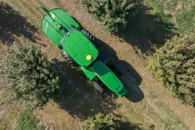 Traktor John Deere při práci v sadech – segment, ve kterém začínají hrát roli elektrické a alternativní pohony.