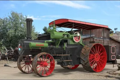 Parní traktor Case se zeleným strojem a červenými koly