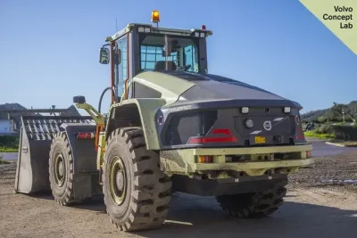 Hybridní nakladač Volvo LX1 zezadu na skládce.
