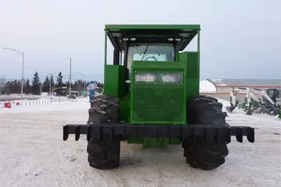 Čelní pohled na zakrytovaný traktor John Deere s ochranným rámem.