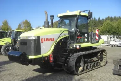 Pásový traktor Claas Challenger odstavený u dalších strojů.