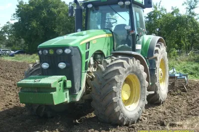 John Deere 8330 s nářadím Lemken na poli.