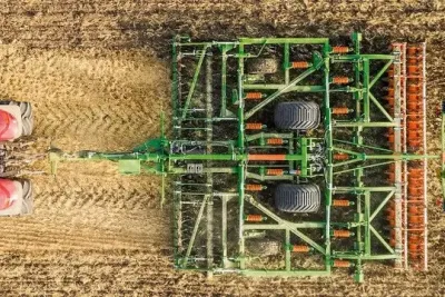 Kombinovaný kypřič Amazone Ceus za červeným traktorem na poli