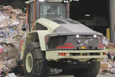 Hybridní nakladač Volvo LX1 při manipulaci s odpadem.