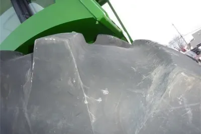 Detail lesní pneumatiky a zakrytování traktoru John Deere.
